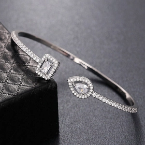 Detailed view of silver cuff bracelet with square and pear-shaped cubic zirconia stones