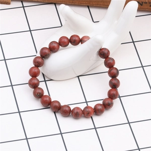 Close-up of red agate beaded bracelet with 8mm round natural stones on a white hand model