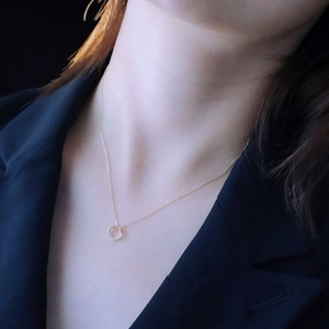 Detailed view of S925 silver square pendant necklace with gold finish on neck