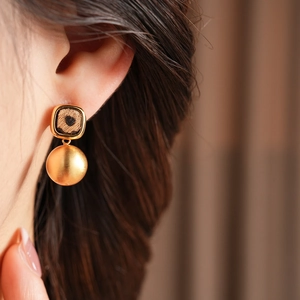 Nahaufnahme einer Dame mit goldenen quadratischen Leopard-Ohrringen im Retro-Design