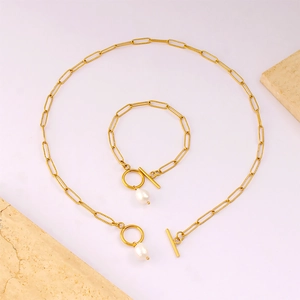 Set di gioielli eleganti in acciaio inossidabile dorato con perle bianche e chiusura a barra