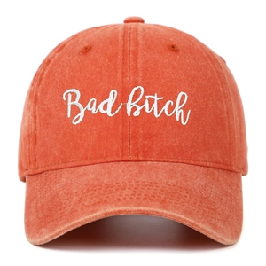 Close-up of Bad Bitch embroidery on washed orange denim cotton baseball cap
