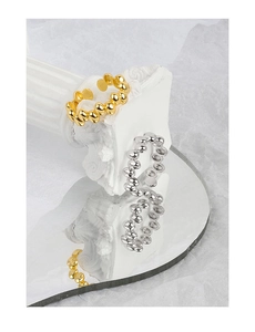 Detailed view of gold and silver S925 sterling silver bubble rings on a mirror surface