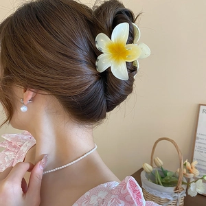 Détail d'une pince à cheveux fleur de frangipanier avec dégradé jaune et blanc