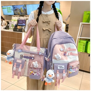Detail of pink and purple school bag set with cute cartoon badges and plush charms