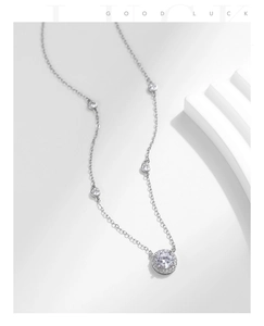 Detail of S925 silver halo diamond necklace with accent stones on a minimalist stand