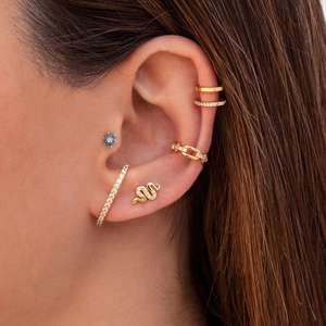 Detailed view of 925 silver golden helix studs and ear cuffs with blue gemstones on ear