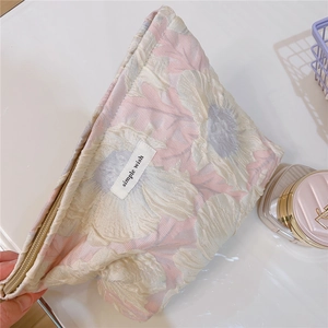 Close-up of pink floral bubble jacquard fabric texture on a soft vanity cosmetic bag