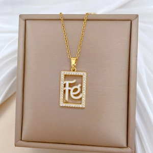 Macro shot of gold hollow square pendant with Fe initials and micro-paved zircons on silk