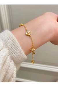 Dettaglio del braccialetto a fiori placcato oro 18K con zirconi e madreperla sul polso