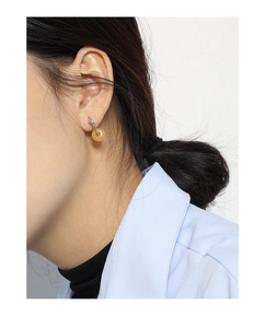 Close-up of minimalist S925 sterling silver hoop earrings with amber jade-like texture