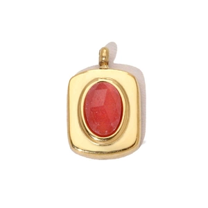 Détail d'un pendentif carré doré avec une pierre précieuse rouge facettée et un anneau