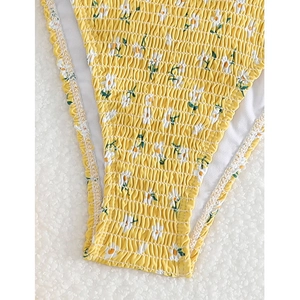 Detail of yellow daisy print bikini bottom with textured smocked fabric and neat stitching