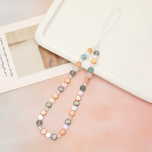 Iridescent beaded phone wrist strap with round crystal beads on a white tray