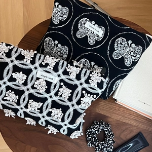 Détail de la trousse en toile noire avec broderie papillon 3D et étiquette simple wish