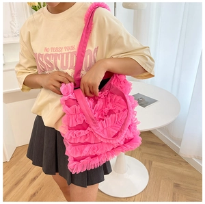 Close-up of pink ruffled mesh tote bag with a unique cake skirt design detail.