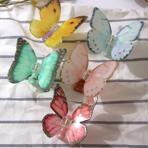 Detail of five colorful butterfly hair claws made of translucent acetate material