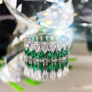 Vue détaillée d'une bague sertie de zircons blancs et d'émeraudes taille poire en double rang