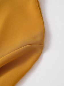 Macro shot of mustard yellow chiffon top showing detailed fabric texture and neat stitching