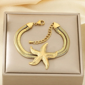 Double-layered gold starfish pendant bracelet on champagne silk fabric display