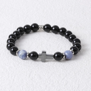 Detailed shot of beaded bracelet with black tiger eye stones and a silver cross pendant
