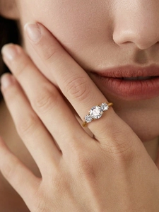 Detailed close-up of a 1 carat three-stone moissanite ring in gold plated 925 silver
