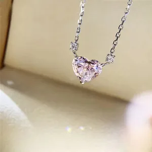 Macro shot of pink heart-shaped crystal pendant on a delicate silver-colored chain