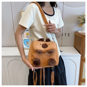 Lifestyle shot of the plush Capybara crossbody bag with adjustable chain strap on a model