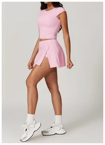 Detail view of pink athletic two-piece set featuring short-sleeve crop top and split skort