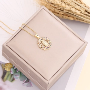 Detail of gold Virgin Mary pendant with colorful cubic zirconia in a gift box