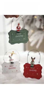 Close-up of Merry Christmas metal signs with Santa and deer charms in festive colors