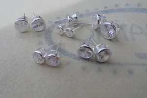 Macro detail of various sizes of round-cut cubic zirconia studs in silver bezel setting