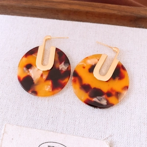 Detailed close-up of tortoise shell acetate earrings with 18K gold plated metal accents