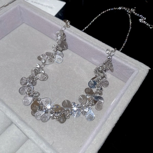 Macro shot of silver teardrop pendant necklace with leaf textures in a plush jewelry box