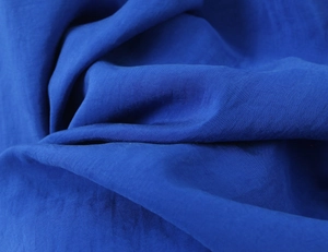 Close-up of smooth navy blue fabric texture with elegant natural folds and drape