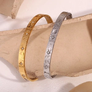 Detail of waterproof 18K gold and silver star bangles with crystals on stone base