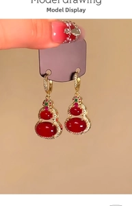 Detail of 14k gold plated red gourd earrings with sparkling zircon accents on display