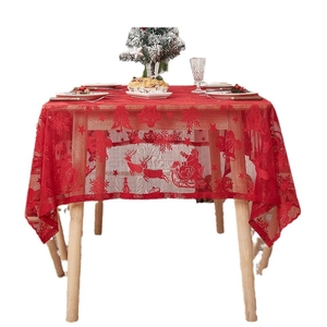 Red Christmas lace tablecloth featuring Santa Claus reindeer and snowflakes on a wooden table