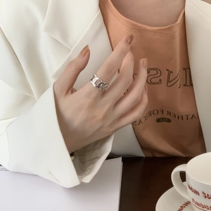 Detail of minimalist S925 silver wide chain ring worn with a modern stylish outfit