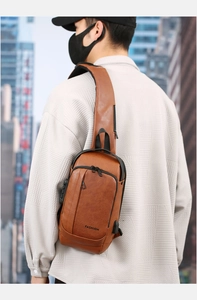 Brown PU leather chest bag with USB port and anti-theft lock shown on a model