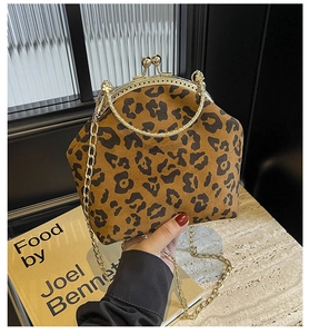 Close-up of leopard print suede shell bag with golden metal frame and chain strap