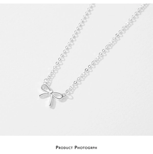 Vue détaillée du pendentif nœud en argent poli sur une chaîne maille fine