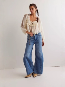 Chemisier femme en tulle crème à nouer avec un jean à jambes larges taille haute