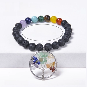 Colorful natural stone beaded bracelet with lava rocks and tree of life charm on white steps