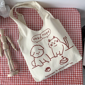 Minimalist canvas cat tote bag on a checkered cloth with artistic lifestyle decor