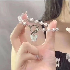 Elegant butterfly pearl bracelet with OT buckle closure shown in close-up hand view