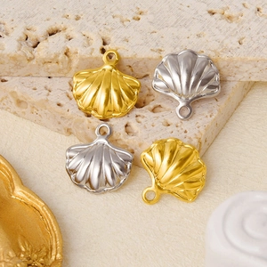 Detailed view of gold and silver shell pendants on a textured stone surface