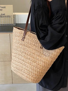 Large straw tote bag with brown leather straps for summer beach or casual daily wear