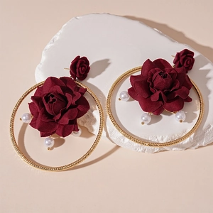 Dettaglio orecchini a rosa in tessuto rosso con cerchio dorato e perle bianche