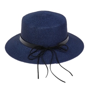 Close-up of navy blue straw hat featuring black leather band and woven texture details